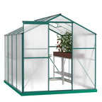 Walk-in polycarbonate greenhouse with hinged door in a garden