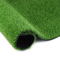 Artificial grass runner rug rolled out on a patio